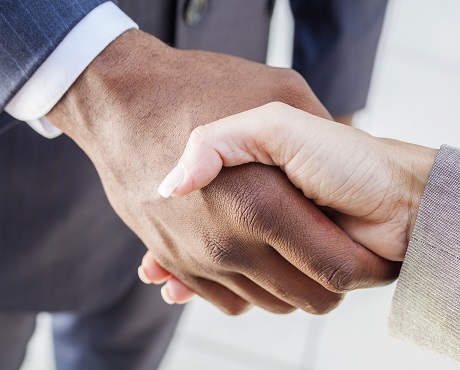 Two suited people shaking hands celebrating business continuity | Kerry London team