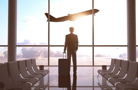 Business travel with man looking through window representing business travel insurance